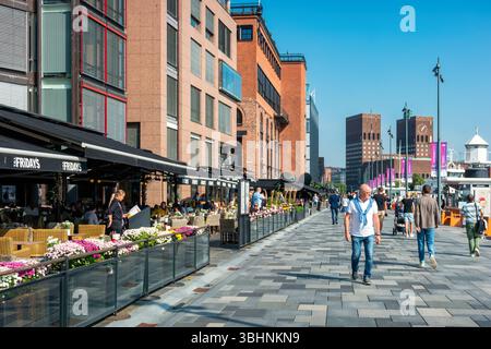 Les gens s'assoient sur des patios et marchent sur la promenade Aker Brygge dans le centre-ville d'Oslo, en Norvège Banque D'Images