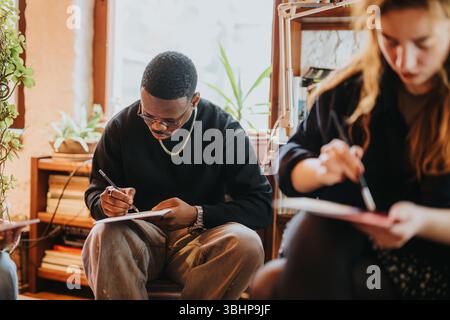 Personnes concentrées s'engageant dans des activités de dessin et de peinture dans un cadre confortable Banque D'Images