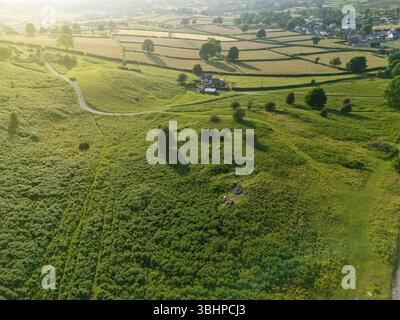 Vue aérienne de la campagne vallonnée près du village de Moel-y-crio dans le nord du pays de Galles alors que le soleil commence à descendre bas dans le ciel, Royaume-Uni Banque D'Images