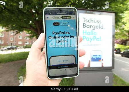 Anti-Bargeld-Werbung auf einer Werbetafel von Ströer vom Online-Bezahldienst PayPal. DAS Unternehmen wirbt aktuell in Deutschland großspurig für die Möglichkeit, mit seiner App kontaklos zu zahlen. Davor hält ein Mann ein smartphone in der hand, auf dem die website von PayPal geöffnet ist. Dort informiert das Unternehmen über die Möglichkeit des kontaklosen Zahlens. Barmbek Hambourg *** publicité anti-cash sur un panneau d'affichage Ströer du service de paiement en ligne PayPal la société annonce actuellement la possibilité de payer sans contact avec son application en Allemagne dans le grand style devant Banque D'Images