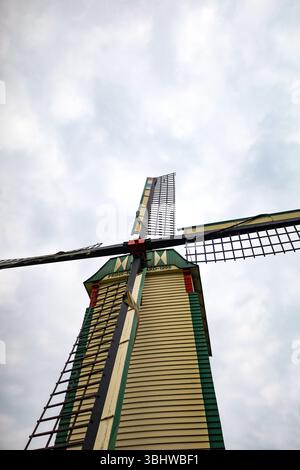 Paysage rural pittoresque avec un étroit chemin de terre serpentant à travers un champ de blé doré menant à un vieux moulin à vent en bois. Banque D'Images