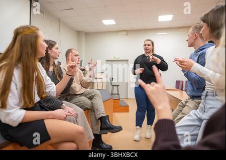 Les jeunes communiquent en langue des signes dans une salle de classe universitaire. Banque D'Images