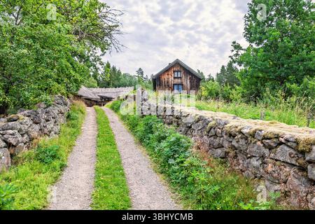 Chemin de terre entre les murs de pierre à un chalet en bois dans la campagne Banque D'Images