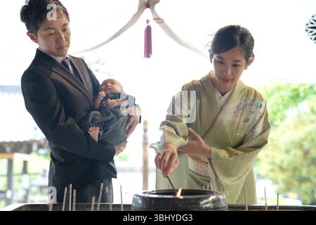 Un jour de printemps en mai dans un temple japonais paisible, un bébé japonais d'un mois est détenu par leur père, tandis que la mère dans la vingtaine, Banque D'Images