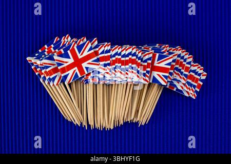 Un paquet de petits drapeaux britanniques sur fond bleu Banque D'Images