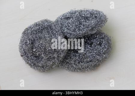 Trois laveuses à vaisselle en acier inoxydable sur une surface en bois clair. Banque D'Images