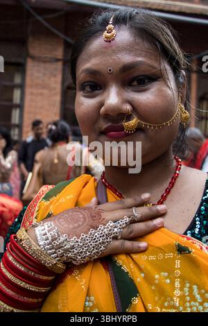 Une femme Tharu porte du Nath (anneau de nez) et du Mangaltika (pendeur de front) pour correspondre à son saari coloré lors du festival Jitiya Pawain à Katmandou, au Népal Banque D'Images