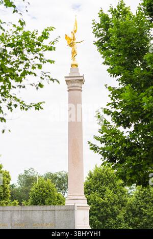 Washington D.C. (États-Unis), 26 mai 2025. Statue dorée de la victoire au sommet du Monument de la première Division, entourée d'arbres verts et d'un ciel bleu. Banque D'Images