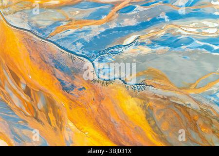 Une œuvre fractale abstraite vibrante avec des motifs tourbillonnants dans des teintes orange vives, bleues et grises. Cette image captivante allie complexité et élégance Banque D'Images