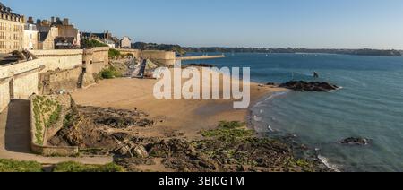 Vue panoramique sur la plage de bon secours et la ville fortifiée historique de Saint-Malo, Bretagne, France, au coucher du soleil. Paysage côtier avec lumière dorée, calme Banque D'Images