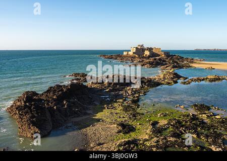 Vue panoramique du Fort National à Saint-Malo, Bretagne, France, vu des remparts de la ville à marée basse avec bassins de marée et côte rocheuse sous une Clea Banque D'Images