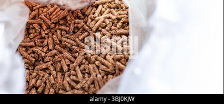 Vue de dessus d'un sac en plastique ouvert rempli de granulés de bois compacts utilisés pour le combustible ou la litière pour animaux. Banque D'Images