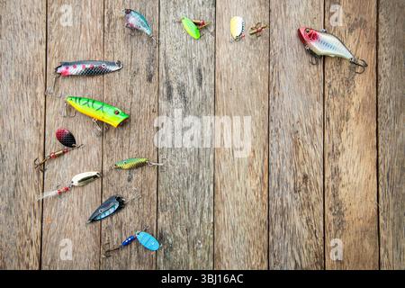 Leurres de pêche assortis et filières de différentes couleurs et tailles sur fond de bois rustique, parfait pour la pêche à la ligne ou les images de stock d'extérieur. Banque D'Images