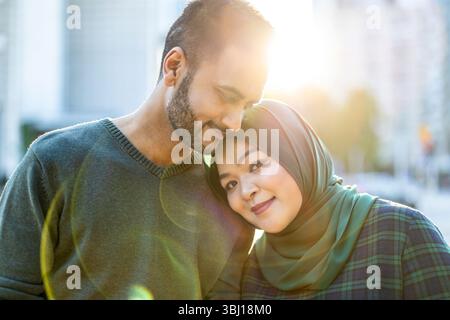 Portrait d'un couple musulman heureux s'embrassant dans la ville Banque D'Images