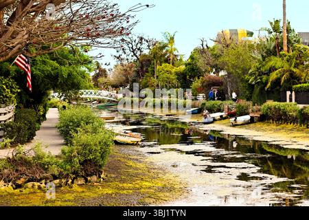 Une vue paisible sur les canaux de Venise à Los Angeles comprend de petits bateaux, une végétation luxuriante, une eau réfléchissante calme et une promenade tranquille serpentant à travers elle Banque D'Images