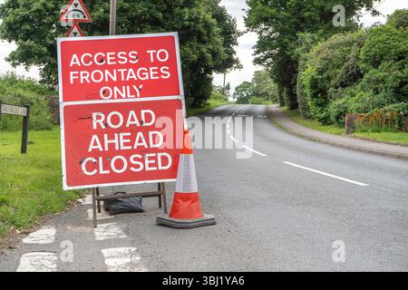 Vue rapprochée d'un panneau de signalisation indiquant que la route est fermée, accès aux façades uniquement, sur une route à double sens britannique. Banque D'Images
