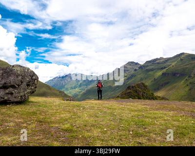 Homme portant un chapeau et portant un sac à dos rouge regarde au-dessus du paysage de Pisac, un complexe archéologique, l'un des plus importants et visite Banque D'Images
