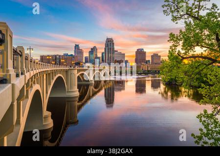 Minneapolis, Minnesota, USA ligne d'horizon du centre-ville sur le fleuve Mississippi avec le pont de la troisième Avenue au crépuscule. Banque D'Images