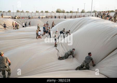 Emplacement non divulgué. 4 juin 2025. Des membres de l'US Air Force affectés à la 380th Air Expeditionary Wing aplatissent un liner sur le site d'installation d'une nouvelle vessie de carburant dans la zone de responsabilité du commandement central des États-Unis, le 4 juin 2025. L'installation de ces deux vessies fournit une capacité de stockage supplémentaire de 420 000 gallons. (Crédit image : © U.S. Air Force/ZUMA Press Wire) USAGE ÉDITORIAL SEULEMENT ! Non destiné à UN USAGE commercial ! Banque D'Images