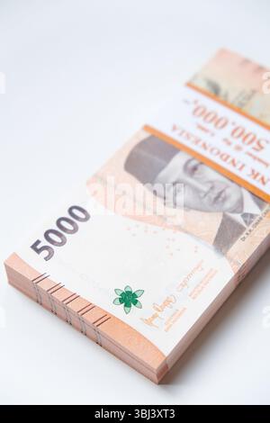 Pekanbaru, Indonésie - 21 mars 2025 : une pile de billets de banque rupiah indonésiens RP 5,000 isolés sur fond blanc pour THR sur Eid al-Fitr ou Lebaran Banque D'Images