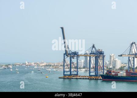 Carthagène, Colombie - 12 avril 2024 : porte-conteneurs au terminal à conteneurs, avec grues et paysage urbain en arrière-plan. Port de Carthagène est Banque D'Images