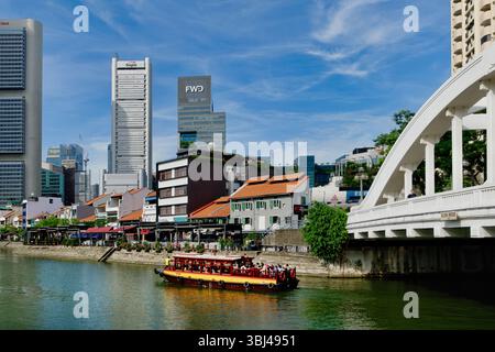 Un bateau d'excursion sur la rivière Singapour passe Elgin Bridge (R) et Boat Quay, des gratte-ciel du quartier des affaires dans le b / g ; Singapour Banque D'Images