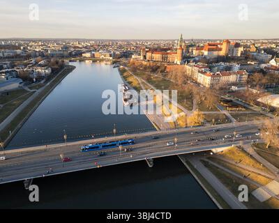 Cracovie, Pologne : vue aérienne d'un tramway conduisant sur un pont au-dessus de la Vistule avec le célèbre château royal de Wawel en arrière-plan sur un w ensoleillé Banque D'Images