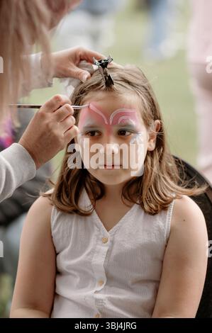 Fille d'enfant obtenant le visage peint à l'événement extérieur. Banque D'Images