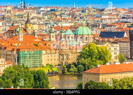 Vue paysagère classique de Prague, République tchèque, avec la rivière Vltava qui coule à travers le premier plan, bordée de ponts historiques, et la ville Banque D'Images