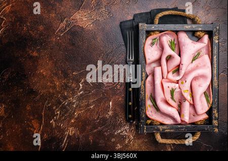 Mortadelle Bologna tranches avec pistaches pour le petit déjeuner en bois. fond marron. vue de dessus Banque D'Images