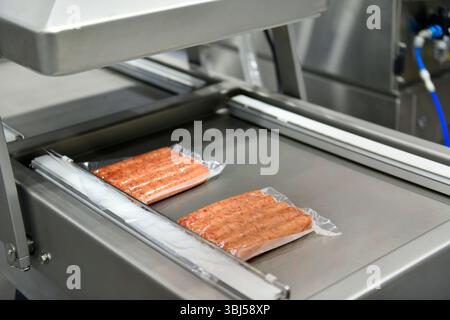 Les machines haute performance emballent des saucisses de produits alimentaires frais transformés. lignes de production alimentaire sur bandes transporteuses, industrie de production alimentaire Banque D'Images
