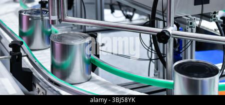 Produits alimentaires en conserve sur le tapis transporteur dans l'entrepôt de distribution. Concept du système de transport des colis Banque D'Images