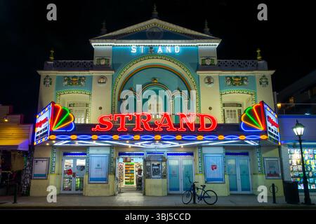 L'ancienne façade historique Strand Theater illuminée par des néons colorés la nuit à Duval Street, Key West, Floride Banque D'Images