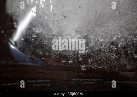 Plan macro d'un bloc de glace avec bulles d'air et textures intégrées, capturé avec un éclairage spectaculaire. La composition abstraite crée un mystérieux, c Banque D'Images