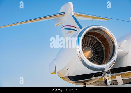 Gros plan du turboréacteur à turboréacteur sur un avion privé, queue et empennage visible sur ciel bleu clair. Jet d'affaires sur tarmac en plein soleil. Banque D'Images