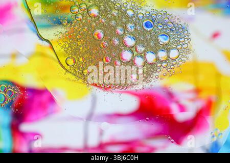 Photo macro d'émulsion eau-huile sur fond coloré Banque D'Images