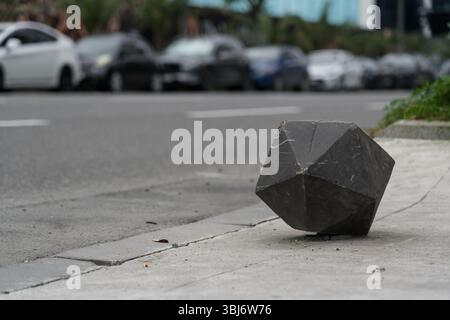 Cube polygonal de clôture en béton sur le fond de la route Banque D'Images