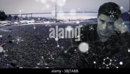 Homme en chemise regardant sur la plage de galets par pont suspendu, bois flotté et superposition de réseau, espace de copie Banque D'Images