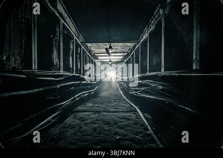 Tunnel de câble en béton sombre est éclairé par la lumière de lampe de poche LED dans l'extrémité. Banque D'Images