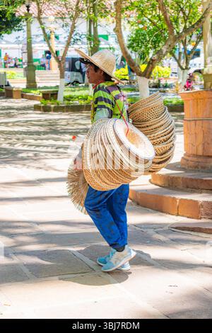 Barichara, Santander, Colombie, 11 octobre 2024. Portrait d’un vendeur de rue vendant des chapeaux de paille tissés dans le parc central de Barichara. L'image est capturée Banque D'Images