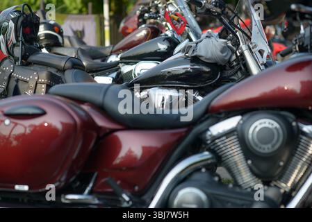 Vue rapprochée de plusieurs motos garées lors de la première journée du Moto Rock Fest à Ruse, Bulgarie, le 13 juin 2025. L'image met en évidence les sièges en cuir, les casques montés, l'équipement cloutés, les réservoirs de carburant et les pièces de moteur chromées. Le festival attire des motards de toute la Bulgarie, la Roumanie, la Macédoine du Nord et d'autres pays, se réunissant pour trois jours de communauté, de musique et de culture moto personnalisée. Cette photo met l'accent sur la variété esthétique et mécanique parmi les vélos, soulignant l'attention portée aux détails et à la personnalisation de l'équipement du pilote et des machines de tourisme. Banque D'Images