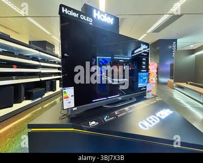 Alicante, Espagne - 11 juin 2025 : télévision OLED Haier exposée dans un magasin d'électronique moderne, mettant en vedette des couleurs vives et une technologie de pointe Banque D'Images