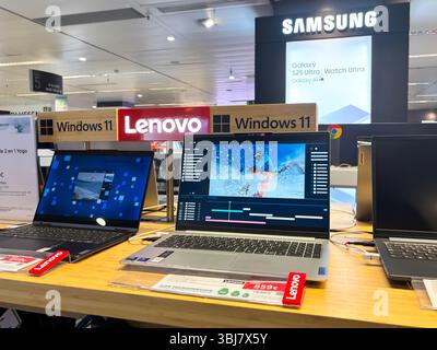 Alicante, Espagne - 11 juin 2025 : ordinateurs portables Lenovo exposés dans le magasin d'électronique avec l'interface Windows 11, mettant en valeur la technologie moderne et dynamique Banque D'Images