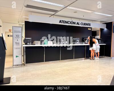 Alicante, Espagne - 11 juin 2025 : espace de service à la clientèle au design moderne avec comptoirs élégants et écrans numériques, mettant en vedette un personnel attentif Banque D'Images