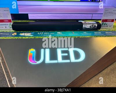 Alicante, Espagne - 11 juin 2025 : écran de télévision ULED avec barre de son sur la table de vitrine, avec des couleurs vibrantes et des étiquettes de prix, mise en évidence Banque D'Images