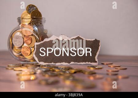 Budget. Pot en verre avec des pièces de monnaie et un budget d'inscription. L'homme tient des pièces de monnaie dans sa main Banque D'Images