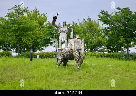 Incheon, Corée du Sud - 19 mai 2025 : un gorille stylisé et un robot humanoïde imposant se tiennent dans un champ herbeux dans un parc de sculptures le long de l'Ara Waterwa Banque D'Images