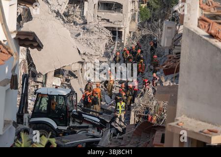 Rishon LeZion, Israël. 14 juin 2025. Les secouristes marchent autour des bâtiments endommagés après qu'un missile iranien a frappé Rishon LeZion, tuant au moins deux personnes et en blessant plusieurs autres. Crédit : Ilia Yefimovich/dpa/Alamy Live News Banque D'Images