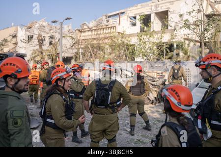 Rishon LeZion, Israël. 14 juin 2025. Les travailleurs des secours se tiennent devant des bâtiments endommagés après qu'un missile iranien a frappé Rishon LeZion, tuant au moins deux personnes et en blessant plusieurs autres. Crédit : Ilia Yefimovich/dpa/Alamy Live News Banque D'Images