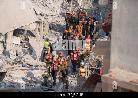 Rishon LeZion, Israël. 14 juin 2025. Les secouristes marchent autour des bâtiments endommagés après qu'un missile iranien a frappé Rishon LeZion, tuant au moins deux personnes et en blessant plusieurs autres. Crédit : Ilia Yefimovich/dpa/Alamy Live News Banque D'Images